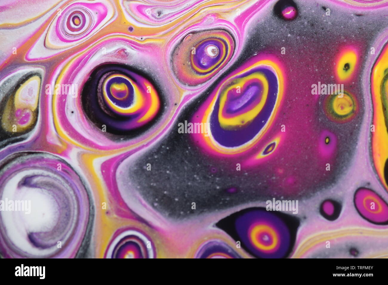Background of a closeup of a psychedelic abstract acrylic pour painting that resembles space or an alien planet. Stock Photo