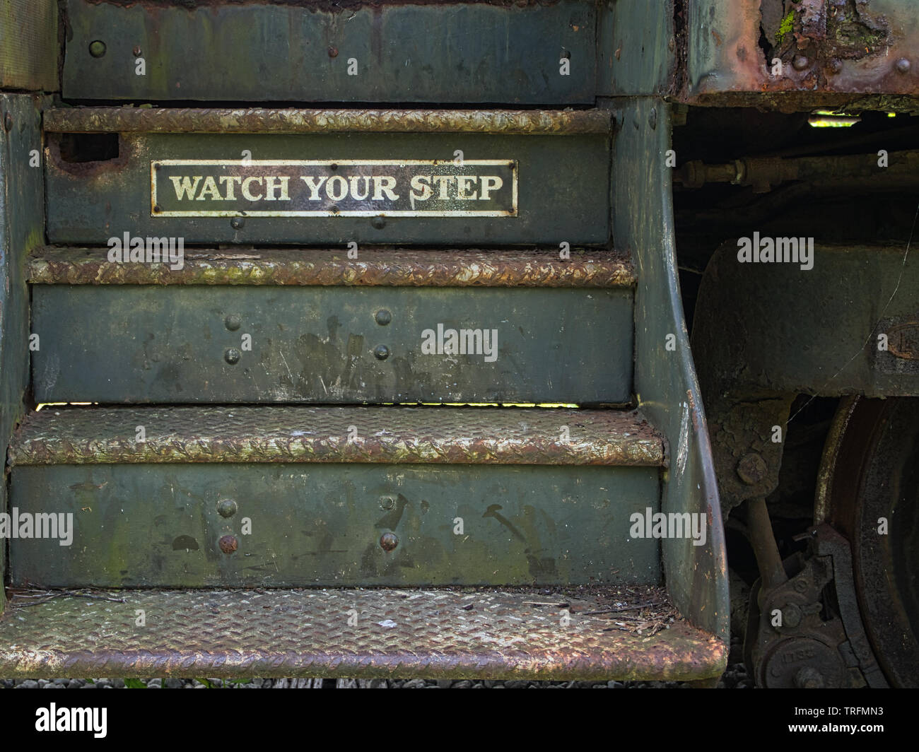 steps into a passenger railway car with a watch your step warning sign Stock Photo