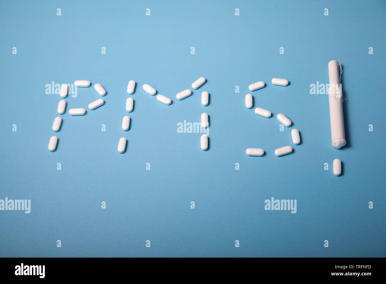 The word PMS spelled out using pain relief pills, as well as a tampon exclamation mark Stock Photo