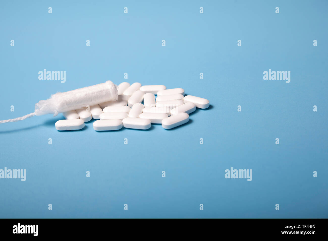 Period pain relief and an unused tampon, signifying PMS or preparing for menstruation Stock Photo