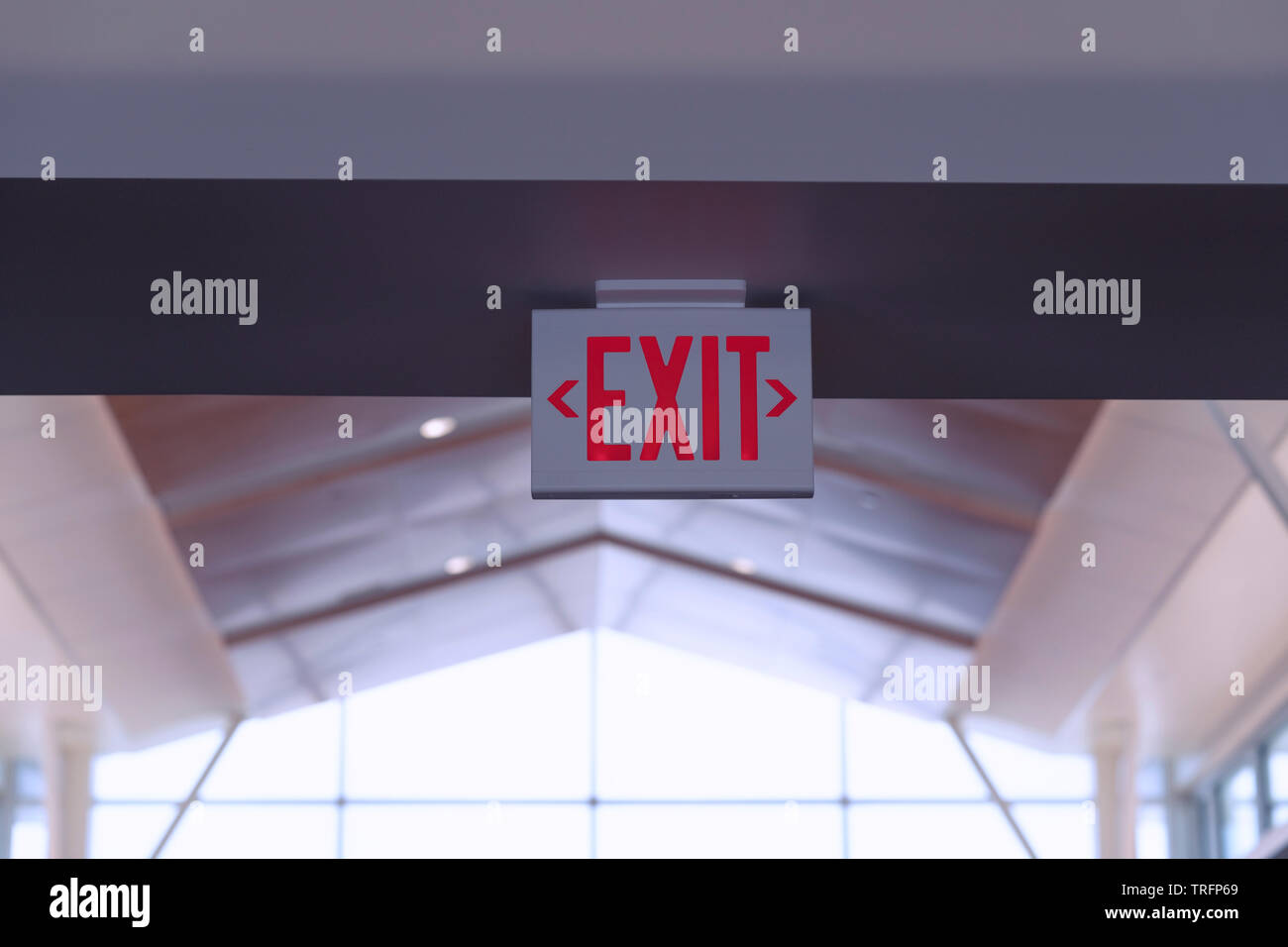 Exit Sign. Red Fire Escape Sign Hang on the Ceiling in the Airport. Stock Photo