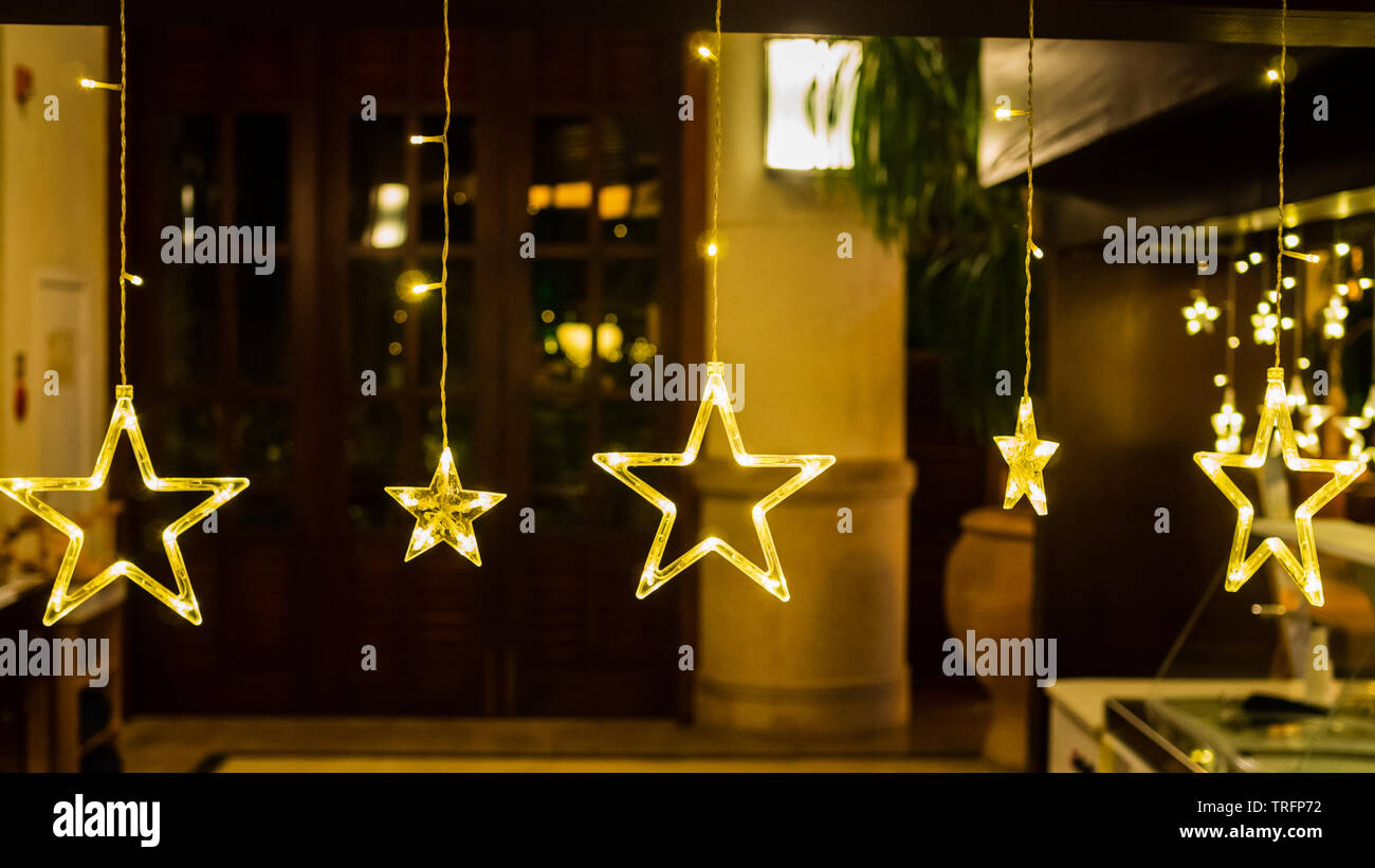 Warm yellow stars in a row against a diffused backdrop create a cosy / festive mood with copy space Stock Photo