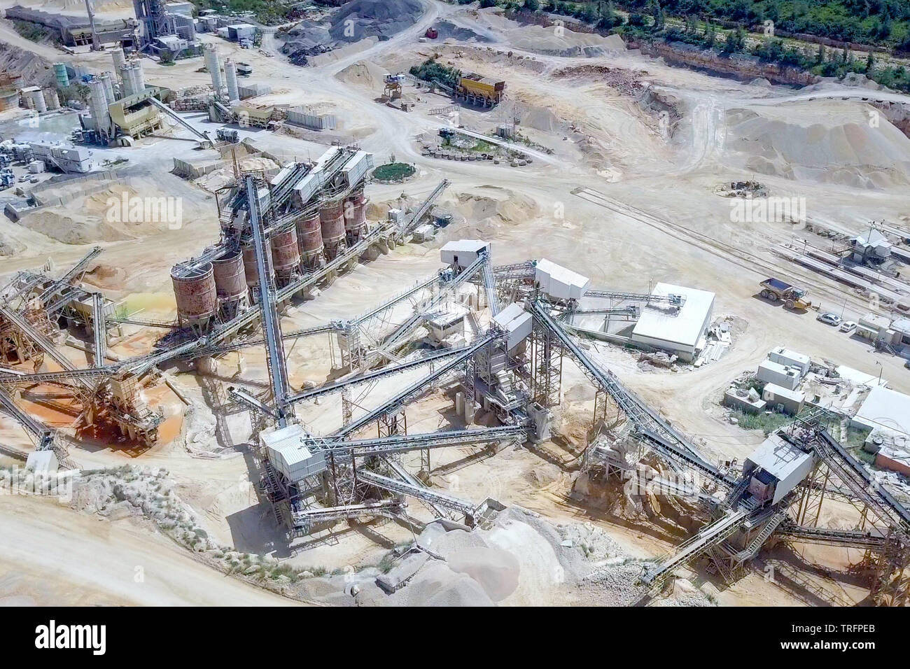 Large Quarry during work hours with Stone sorting conveyor belts - Aerial tour. Stock Photo