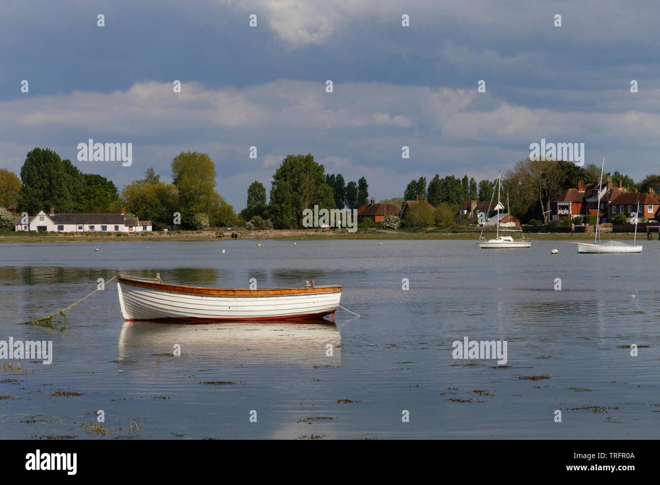 Boat moored in the foreground in the waters around Bosham Harbour West Sussex Stock Photo