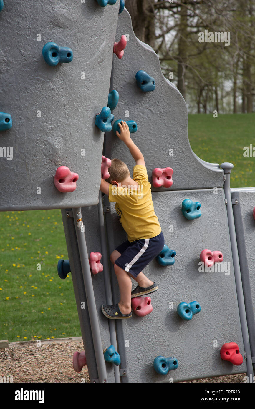 A young boy climbs the rock wall in the playground at Shoaff Park, a