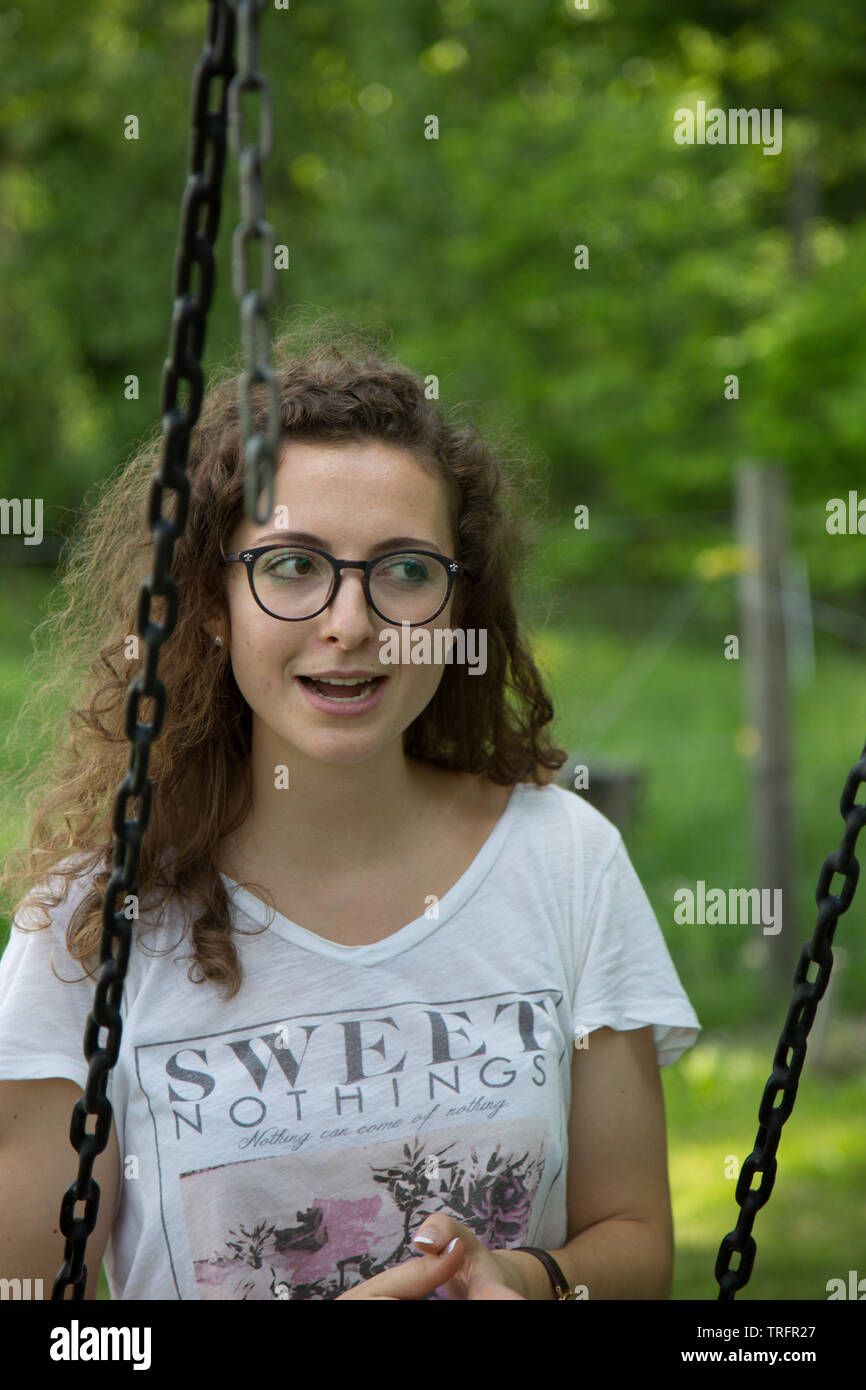 A pretty young girl stares in disbelief while on a swing near Spencerville, Indiana, USA. Stock Photo