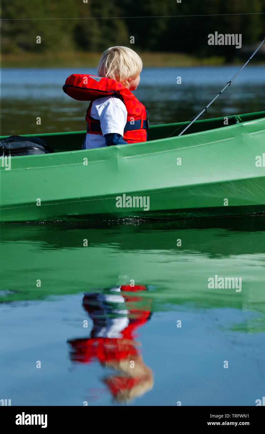 A young boy in a canoe in the lake Vansjø, Østfold, Norway. Vansjø is the largest lake in Østfold. The lake Vansjø and its surrounding lakes and rivers are a part of the water system called Morsavassdraget. September, 2006. Stock Photo