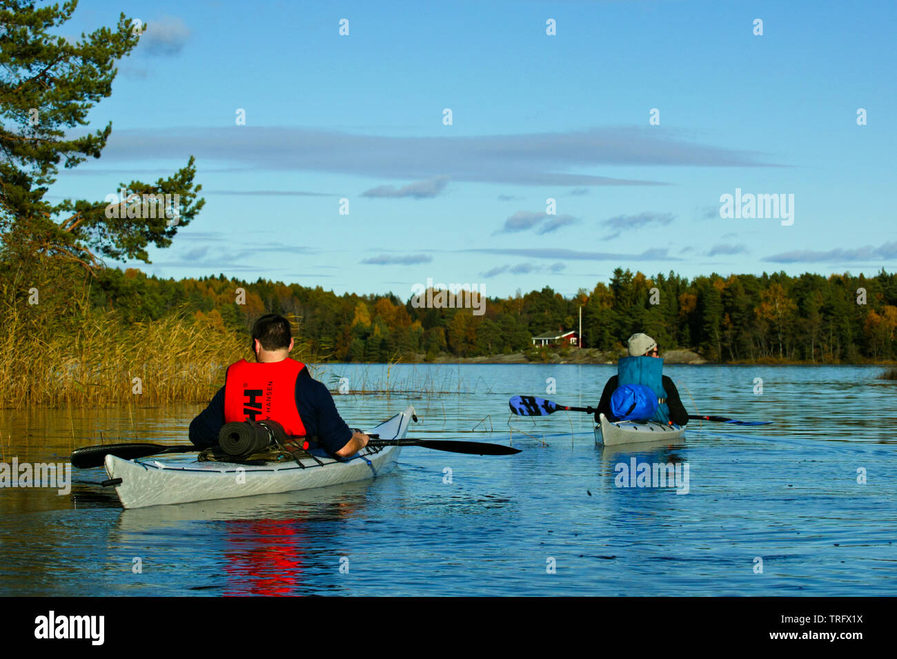 Two kayakers paddling on the lake Vansjø in Østfold, Norway. Vansjø is the largest lake in Østfold. Vansjø and its surrounding lakes and rivers are a part of the water system called Morsavassdraget. October, 2004. Stock Photo