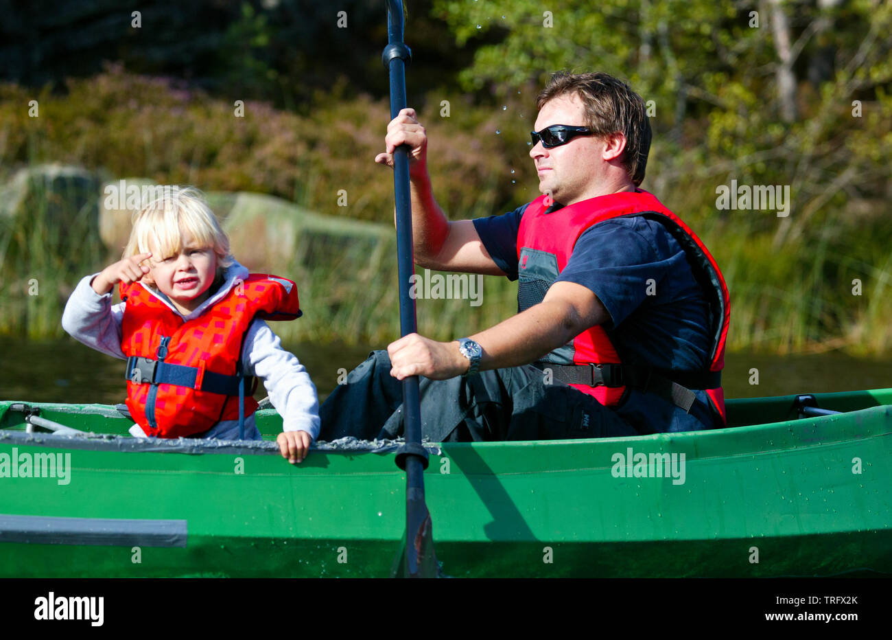 Father and son in a canoe on the lake Vansjø in Østfold, Norway. Vansjø is the largest lake in Østfold. The lake Vansjø and its surrounding lakes and rivers are a part of the water system called Morsavassdraget. September, 2006. Stock Photo