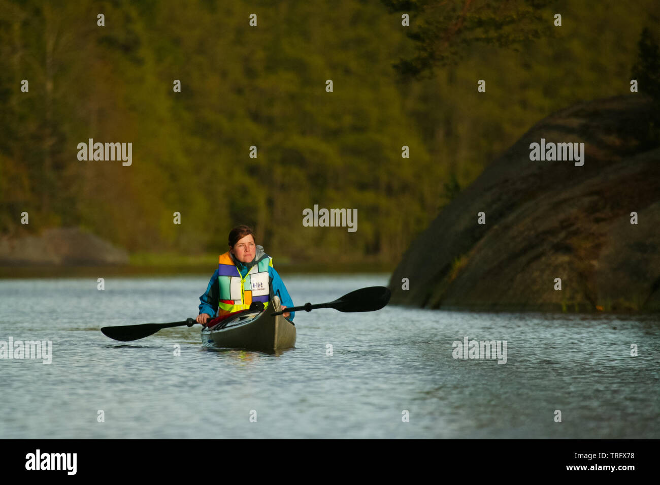 Female paddler in a kayak on the lake Vansjø in Østfold, Norway. Vansjø is the largest lake in Østfold. The lake Vansjø and its surrounding lakes and rivers are a part of the water system called Morsavassdraget. May, 2006. Stock Photo