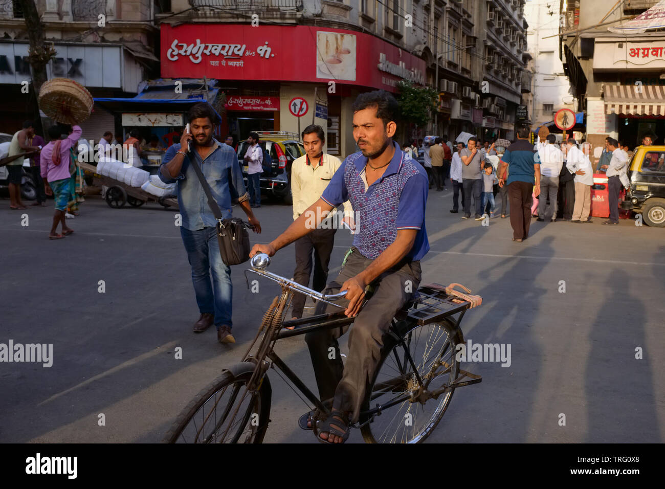 A cyclist rides through Kalbadevi Rd., Bhuleshawar, Mumbai, India, one of the city's major trading areas Stock Photo