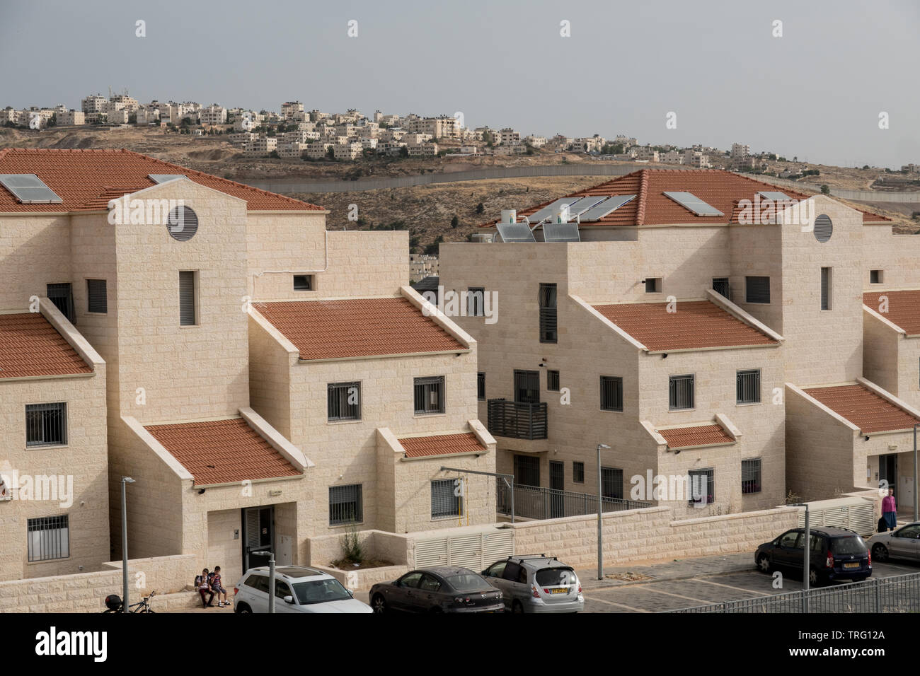 Jerusalem, Israel. 5th June, 2019. A northward view in Jerusalem's Pisgat Zeev neighborhood depicts recently constructed red roofed homes in the foreground with Israel's security barrier in mid ground and the outskirts of Palestinian Qalandiya and Jaba beyond. Israel's Housing Ministry recently published tenders for the construction of 805 new housing units in the Ramot and Pisgat Zeev neighborhoods drawing EU condemnation (1st June, 2019) stating “The European Union is strongly opposed to Israel's settlement policy, including in East Jerusalem, which is illegal under international law and an Stock Photo