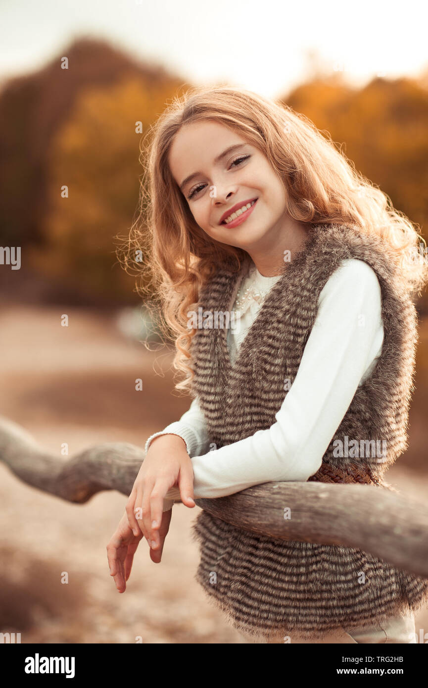 Beautiful teen girl 12-14 year old wearing trendy autumn clothes posing at  countryside. Looking at camera. Stock Photo