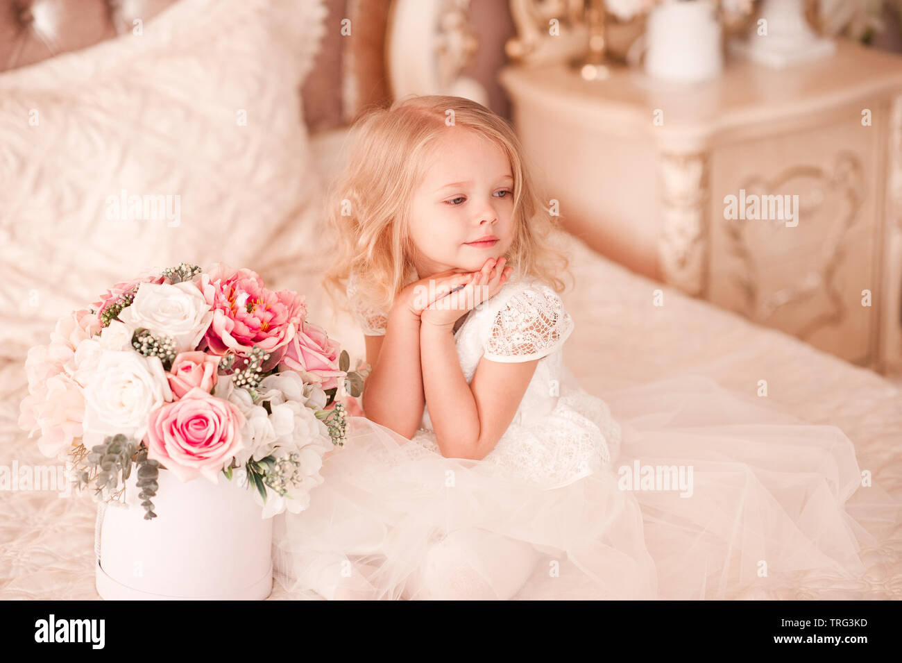 Beautiful baby girl wearing stylish white dress and psong in bed ...