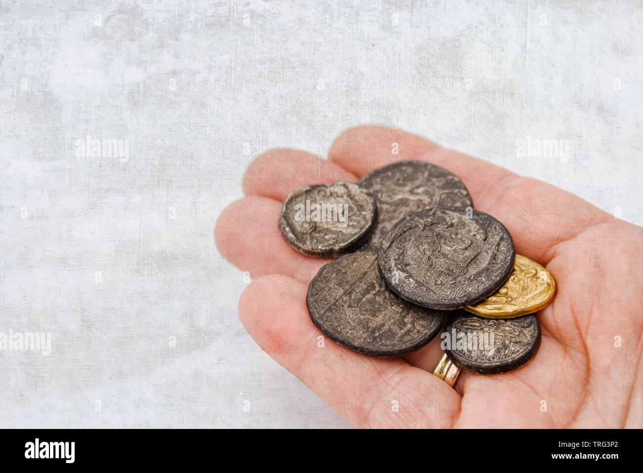 Hand with a collection of old roman coins Stock Photo