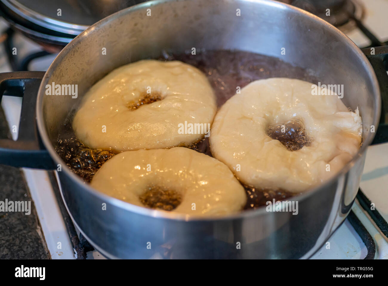 Boiling american bagel before being baked Stock Photo Alamy