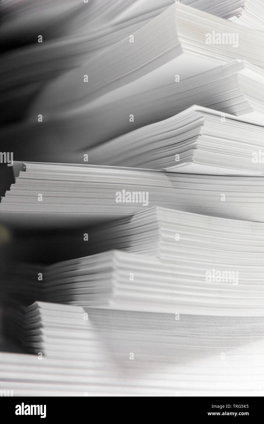 Plain paper stacked high in groups for sorting. Stock Photo