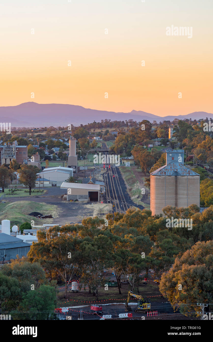 A morning sunrise bathes the town of Gunnedah in a warm glow. Looking south from Pensioner's Hill to the Namoi Flour Mills and the main town beyond. Stock Photo