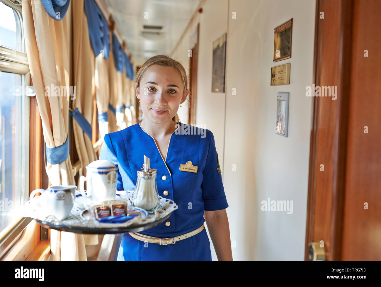 Car conductor in the luxury Trans-siberian Express; 'Golden Eagle' luxury Train, room service; Russian railway; conductress; professional occupation Stock Photo