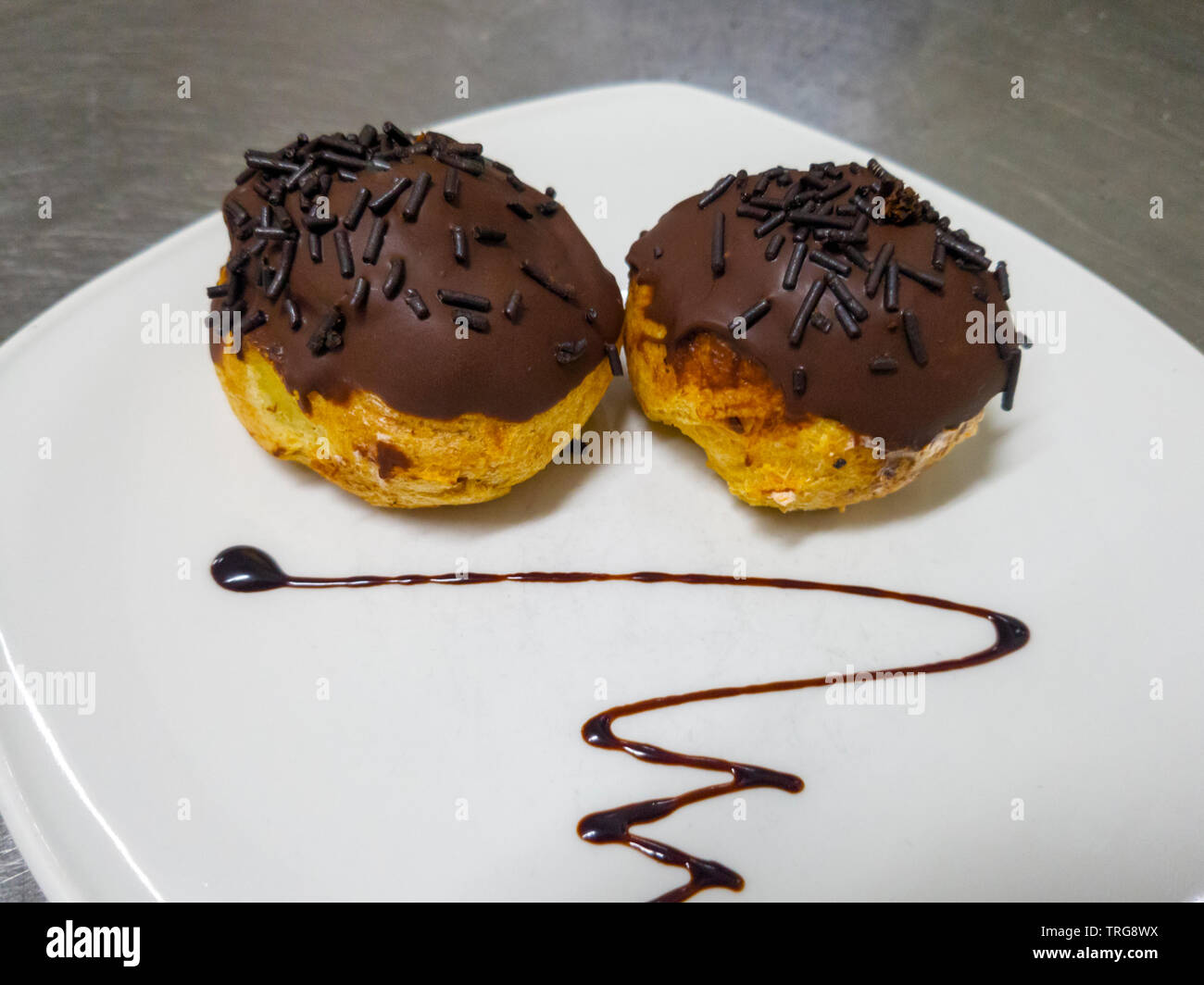 profiterol covered in chocolate and dragee Stock Photo