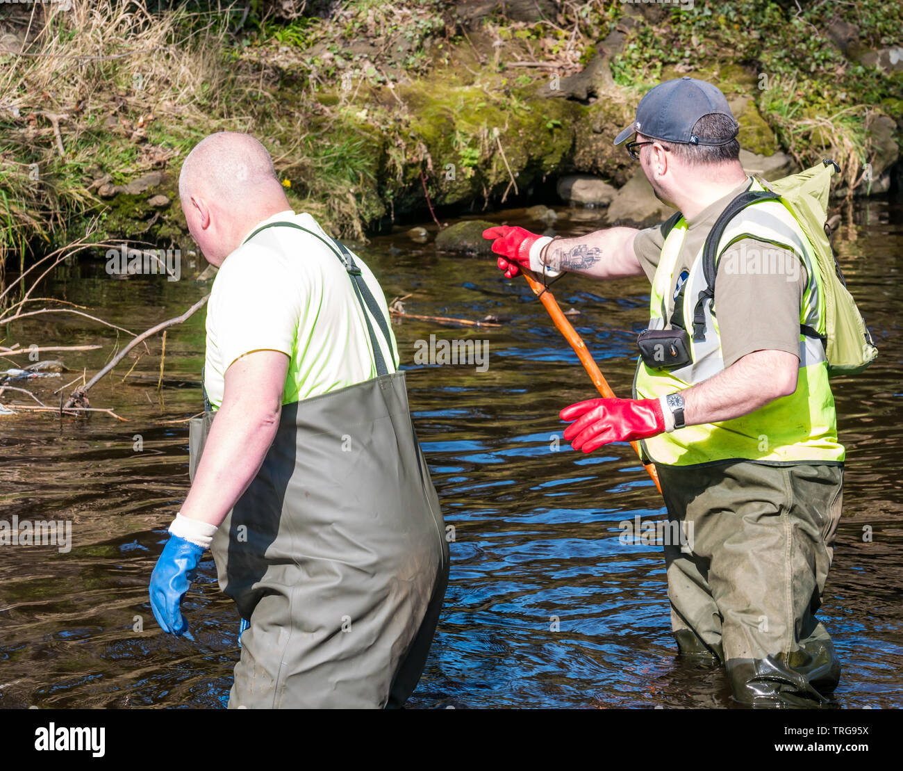 https://c8.alamy.com/comp/TRG95X/volunteer-at-annual-spring-clean-on-bank-of-water-of-leith-edinburgh-scotland-uk-men-in-waders-pull-on-a-rope-to-retrieve-rubbish-TRG95X.jpg
