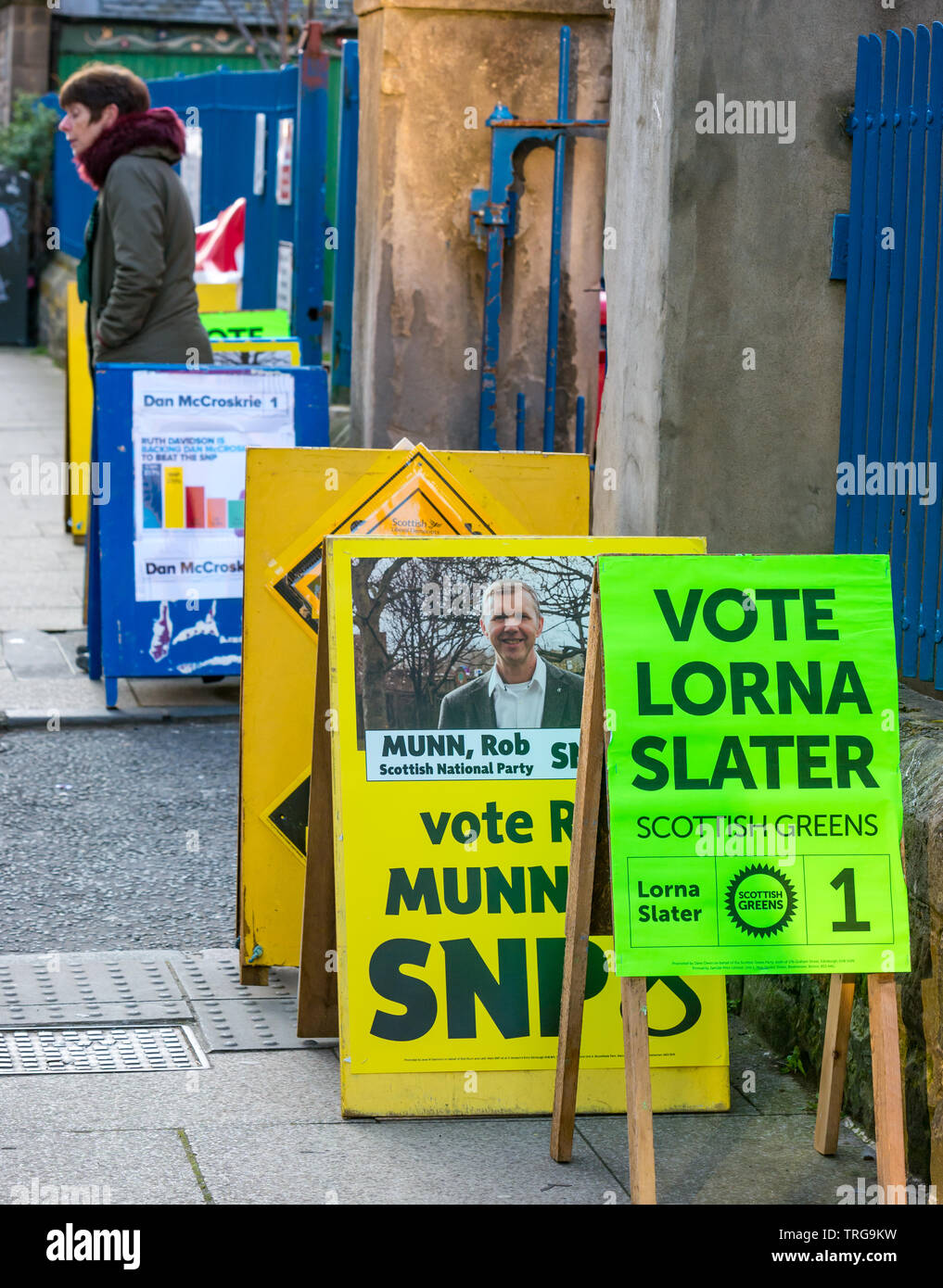 Man walking past Lorne Primary School polling place at Leith Walk Council By-Election, Edinburgh, Scotland, UK with party political boards Stock Photo