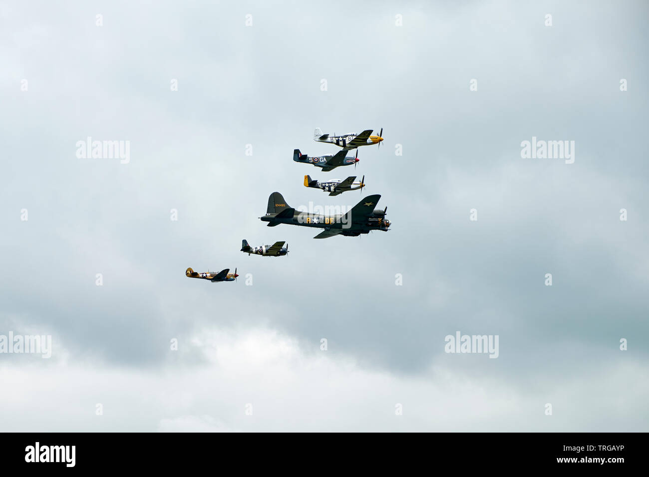 USAF P-51 Mustangs with D-day invasion stripes fly in formation with B17 Flying Fortress at Duxford Stock Photo