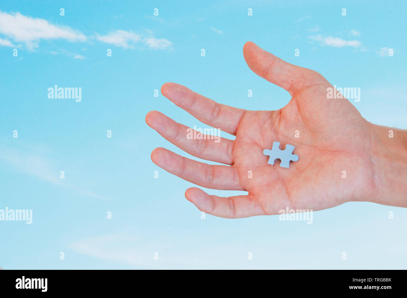 Piece of puzzle in man's hand. Stock Photo
