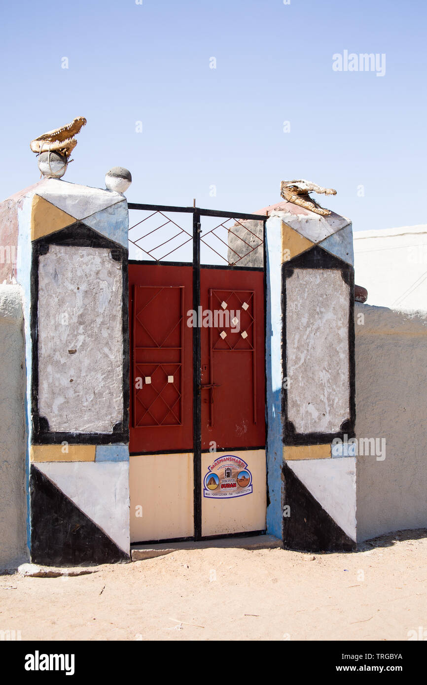 The gateway to a small hotel in the village of Soleb, Sudan, opposite the temple of Soleb. The gate pillars are topped by skulls of Nile crocodiles Stock Photo