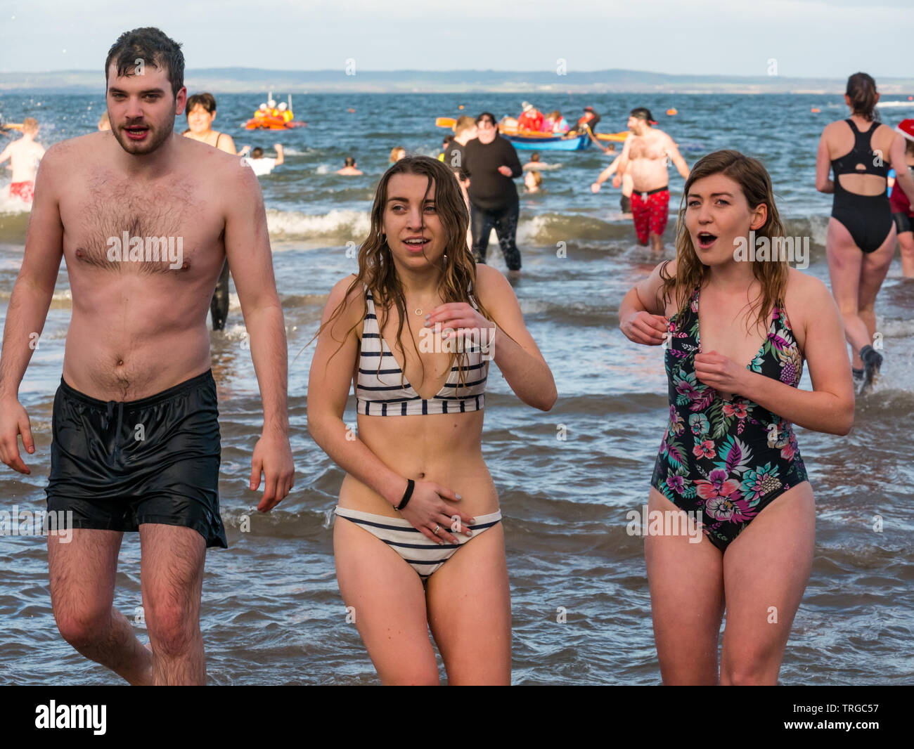 Loony Dook , New Year's Day: People brave cold water, Firth of Forth, North Berwick, East Lothian, Scotland, UK. Young women in swimsuits looking cold Stock Photo