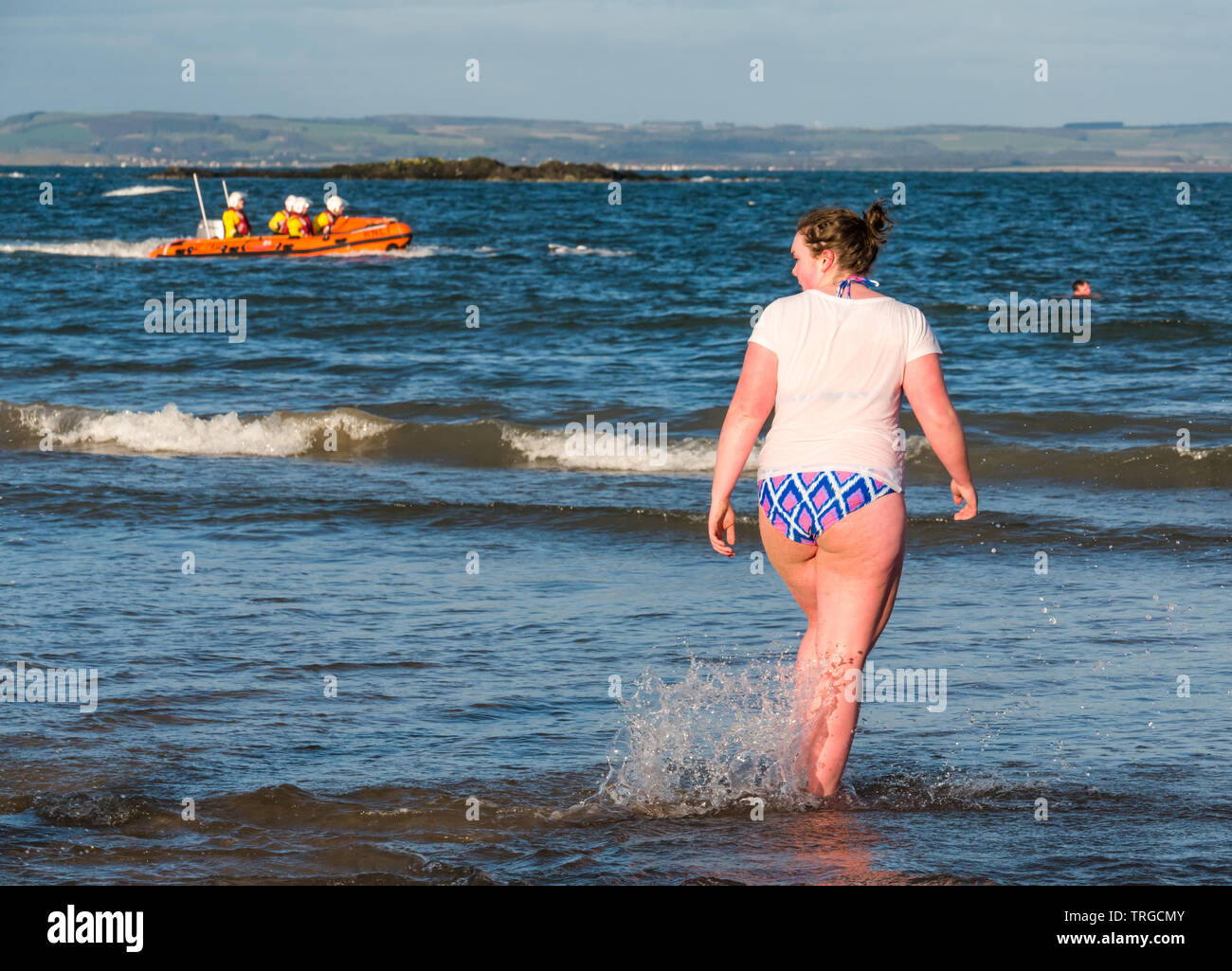 Loony Dook, New Year's Day: People brave cold water of West Bay, Firth of Forth, North Berwick, East Lothian, Scotland, UK. A woman goes into the sea Stock Photo