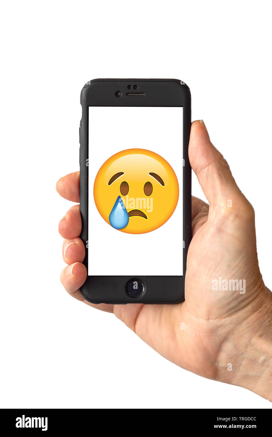 Crying Face Emoji on a smartphone screen Stock Photo