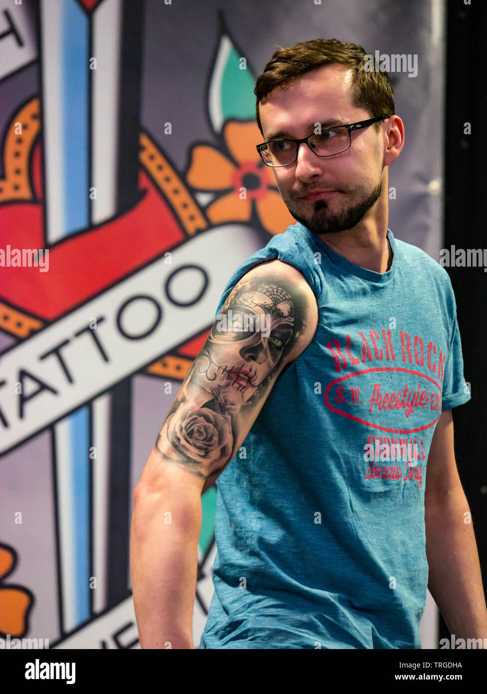 Corn Exchange, Edinburgh, Scotland, UK, 9th Annual Scottish Tattoo Convention:  A man shows off his arm tattoo in a tattoo competition Stock Photo