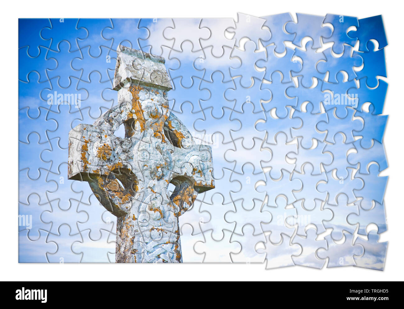 Patiently building of faith - Celtic carved stone cross against a sky background - concept image in jigsaw puzzle shape Stock Photo