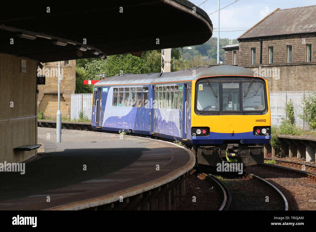 Class 144e Pacer Evolution diesel multiple unit leaving Carnforth framed by platform 2 and the longest unsupported curved platform roof in the country. Stock Photo