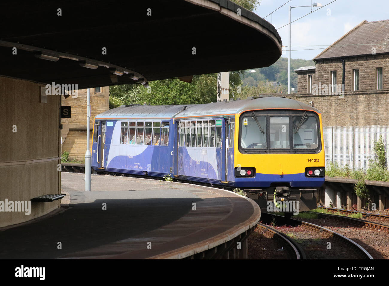 Class 144e Pacer Evolution diesel multiple unit leaving Carnforth framed by platform 2 and the longest unsupported curved platform roof in the country. Stock Photo