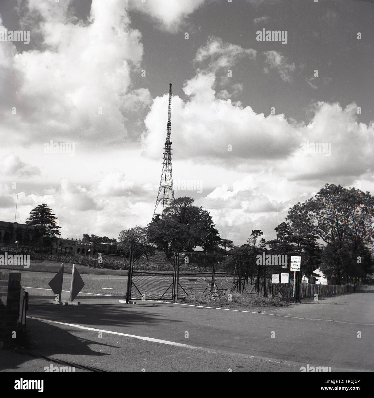 1960s, historical, Crystal Palace Park, showing a gated entrance to the motor racing track and in the distance the UHF broadcasting tower, South London, England, UK. Completed in 1957, Crystal Palace tower is the tallest free-standing lattice transmitting structure in the UK. Stock Photo