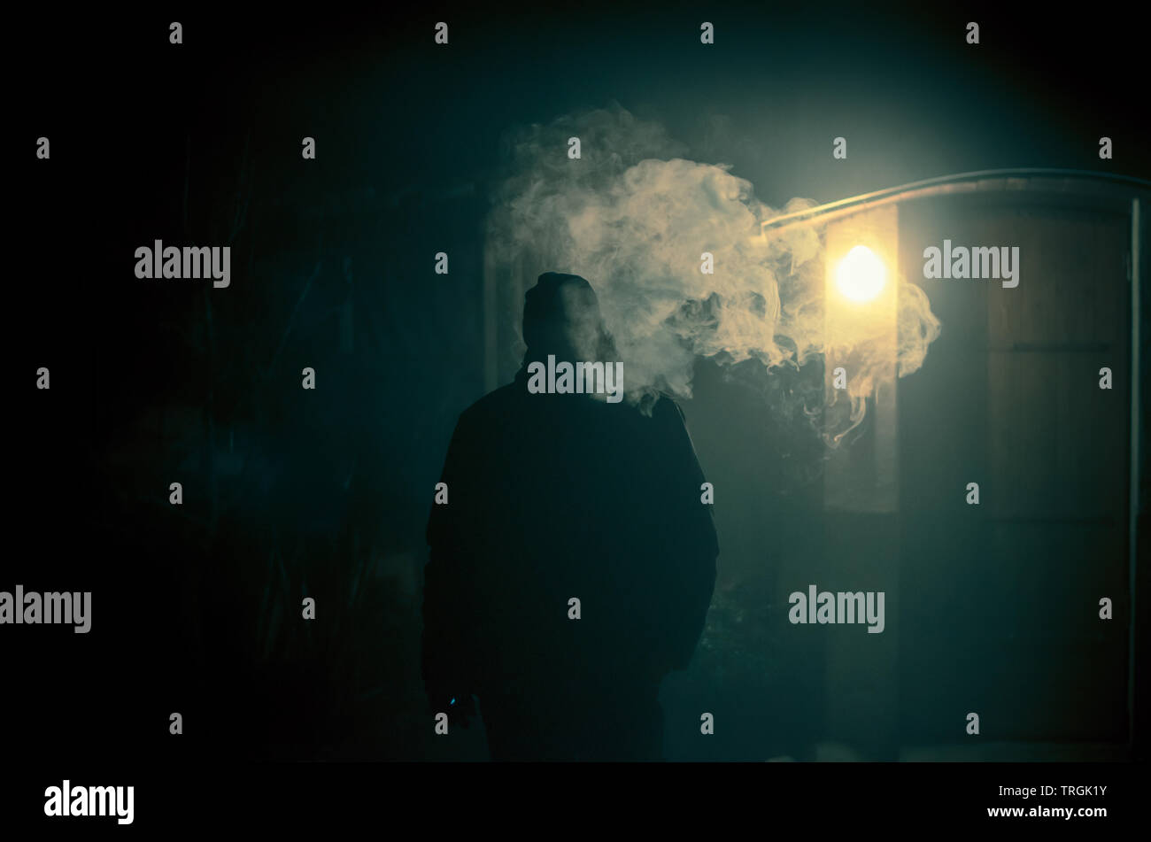 strange man smoking at night with big steam effect from the cigarette Stock Photo
