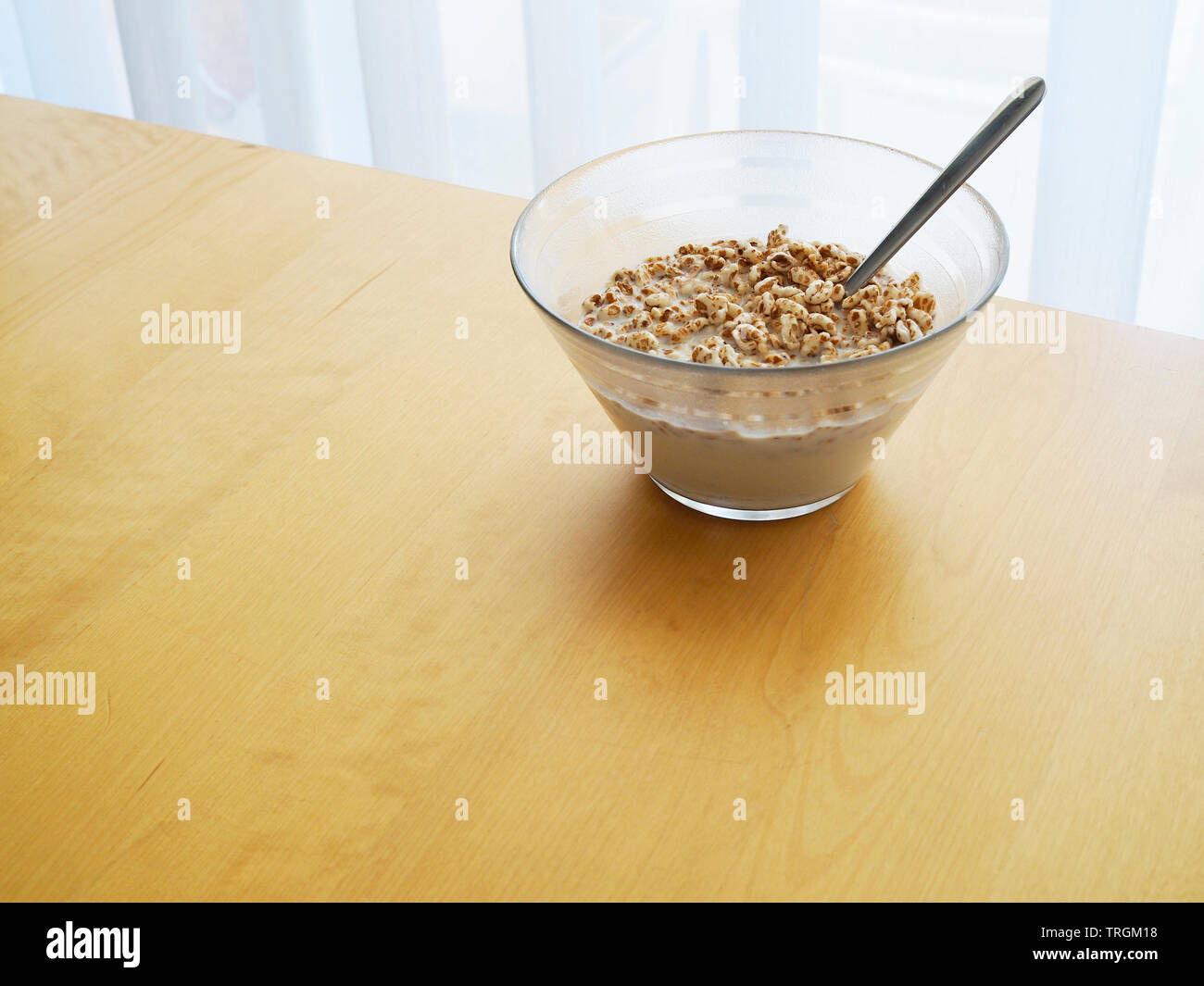 Frühstück, gepufftes Getreide mit Milch in Glasschüssel Stock Photo