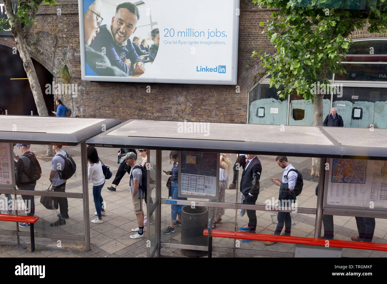 Beneath a billboard ad for online jobs website LinkedIn a queue of bus  passengers wait for the next service at Waterloo Station during the morning  rush-hour, on 5th June 2019, in London,