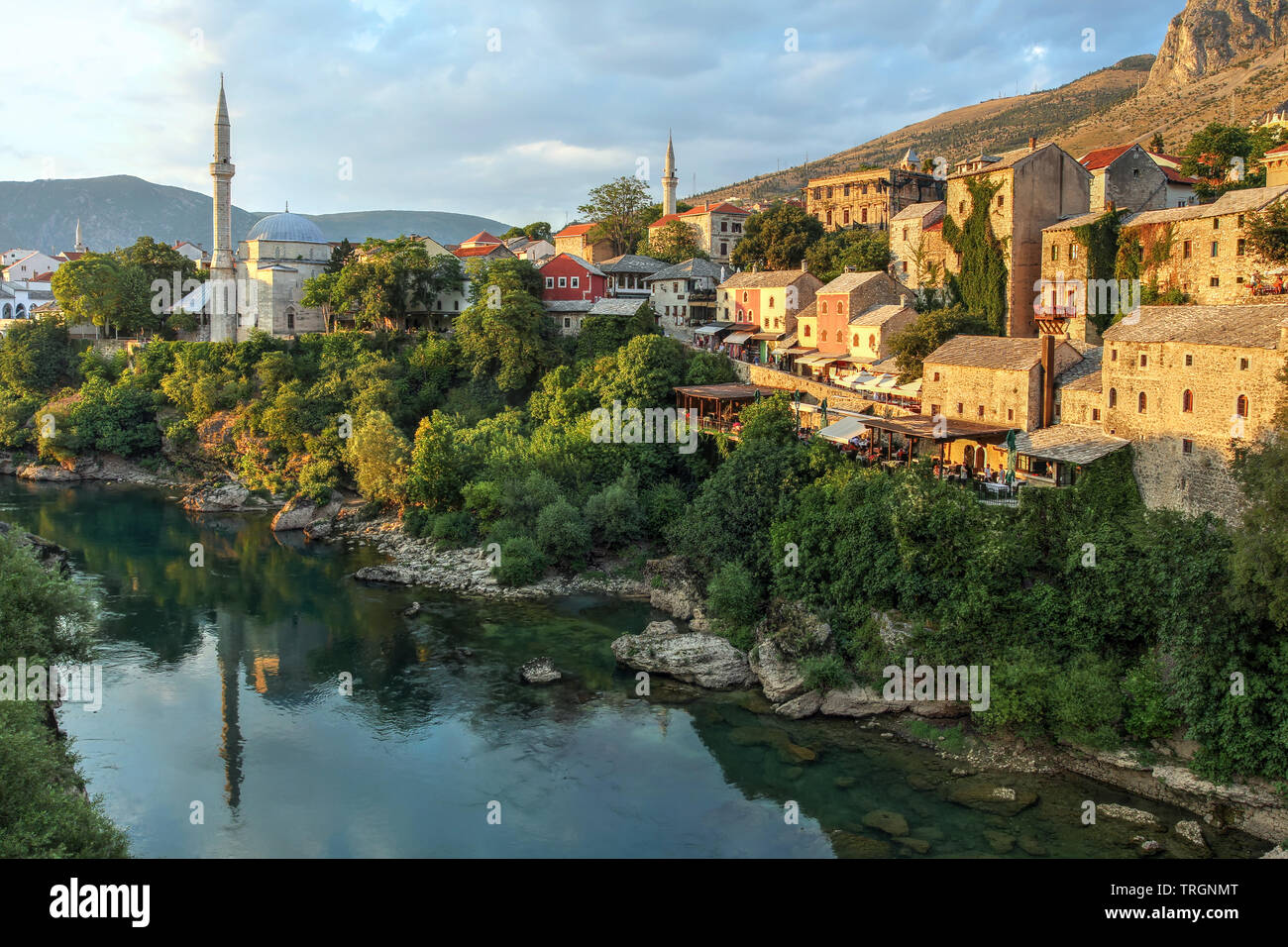 Golden hour over the Neretva river banks of the city of Mostar in Bosnia and Herzegovina seen from the famous bridge. Stock Photo