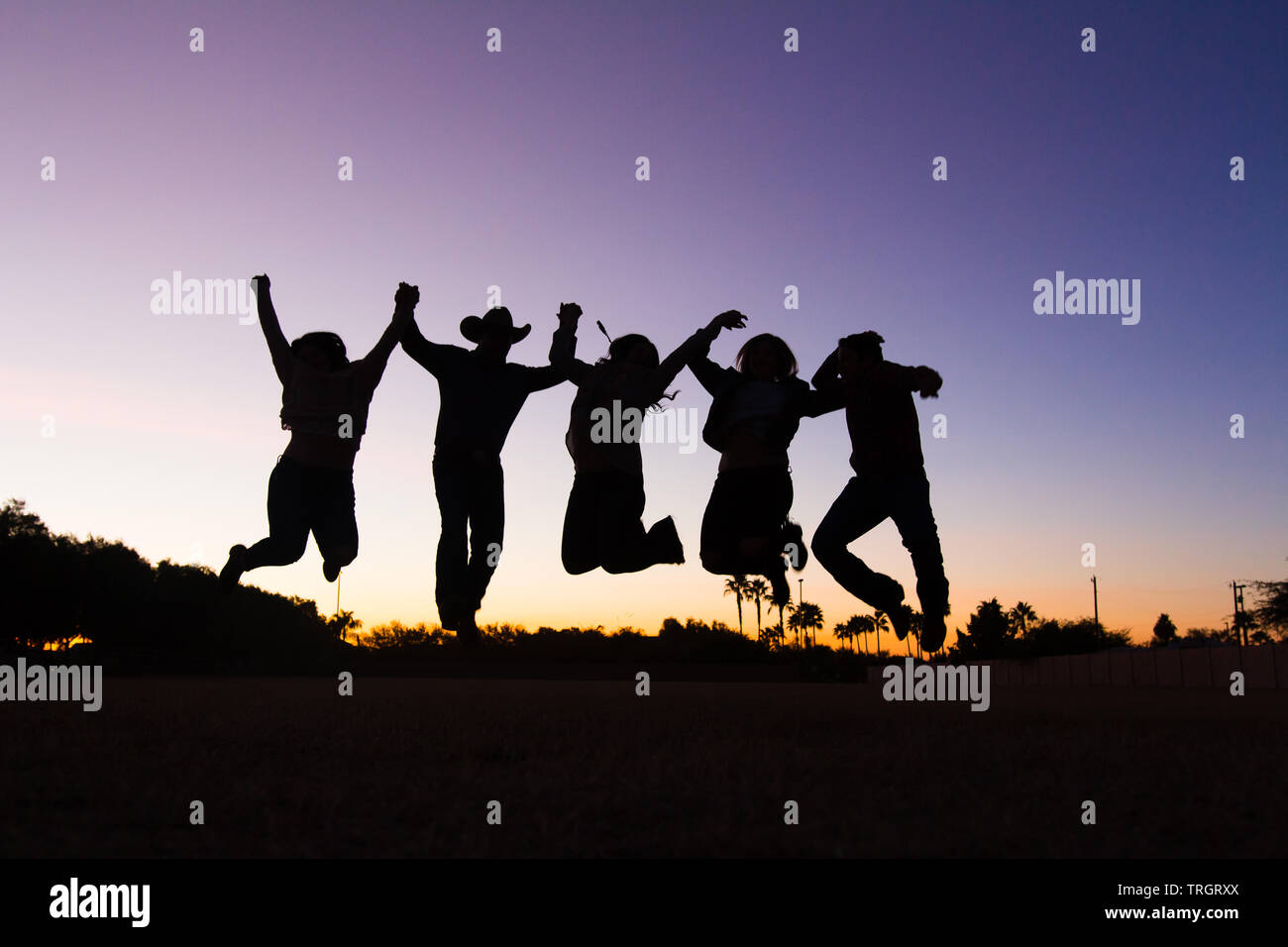 Country Family in the sunset dancing and jumping Stock Photo