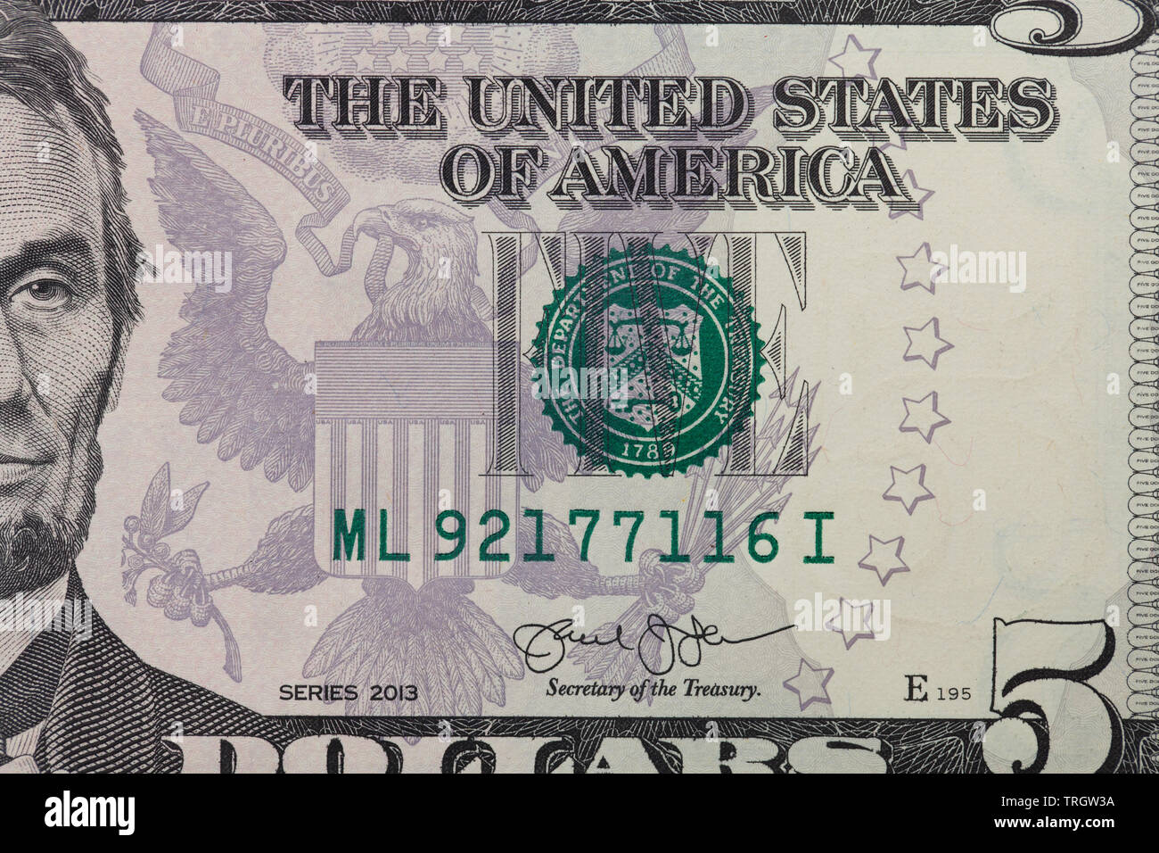 Front of a 5 dollar bill with focus on the FIVE and part of Abraham Lincoln Stock Photo