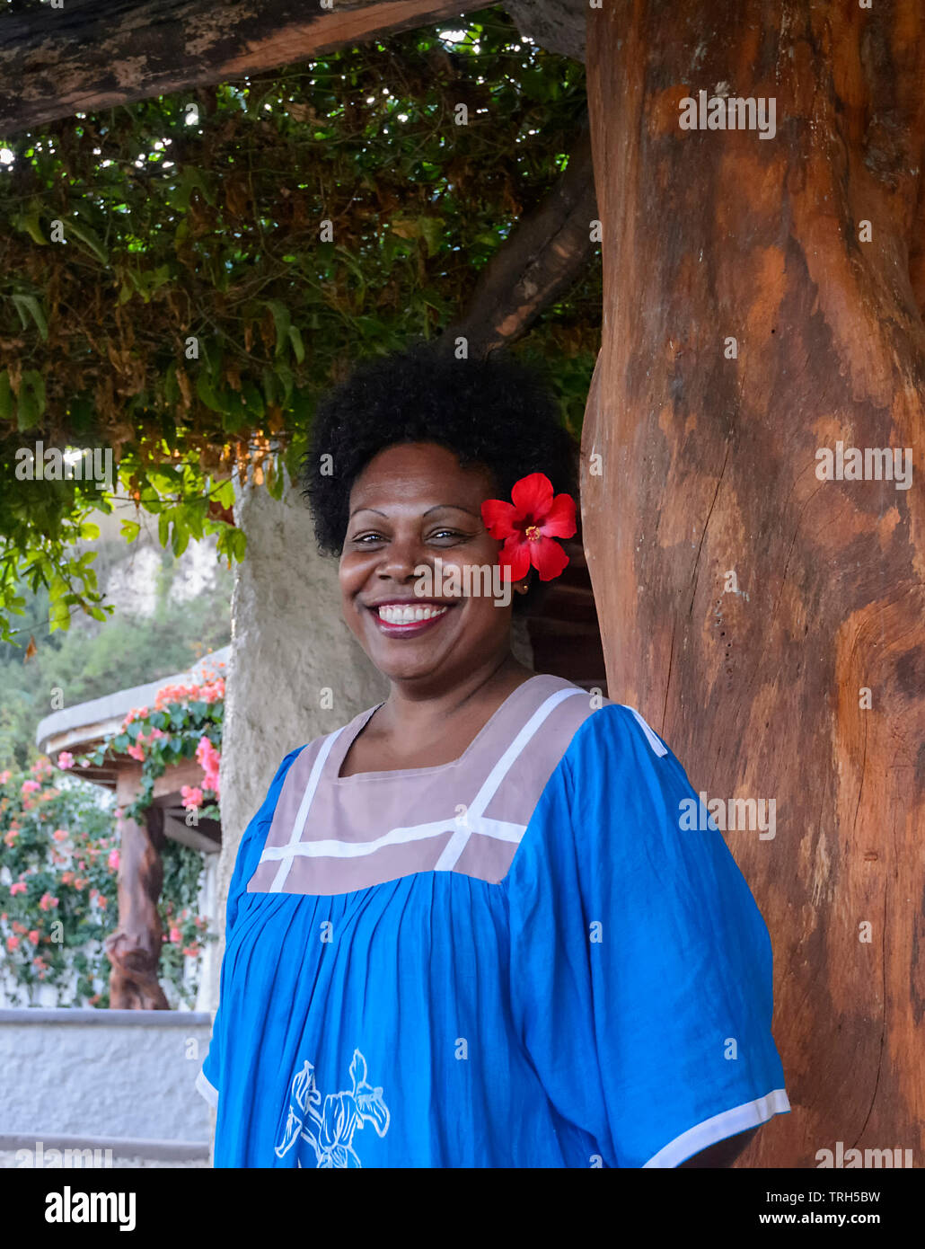 Portrait of a smiling happy Melanesian woman wearing a hibiscus flower on Tanna Island, Vanuatu Stock Photo