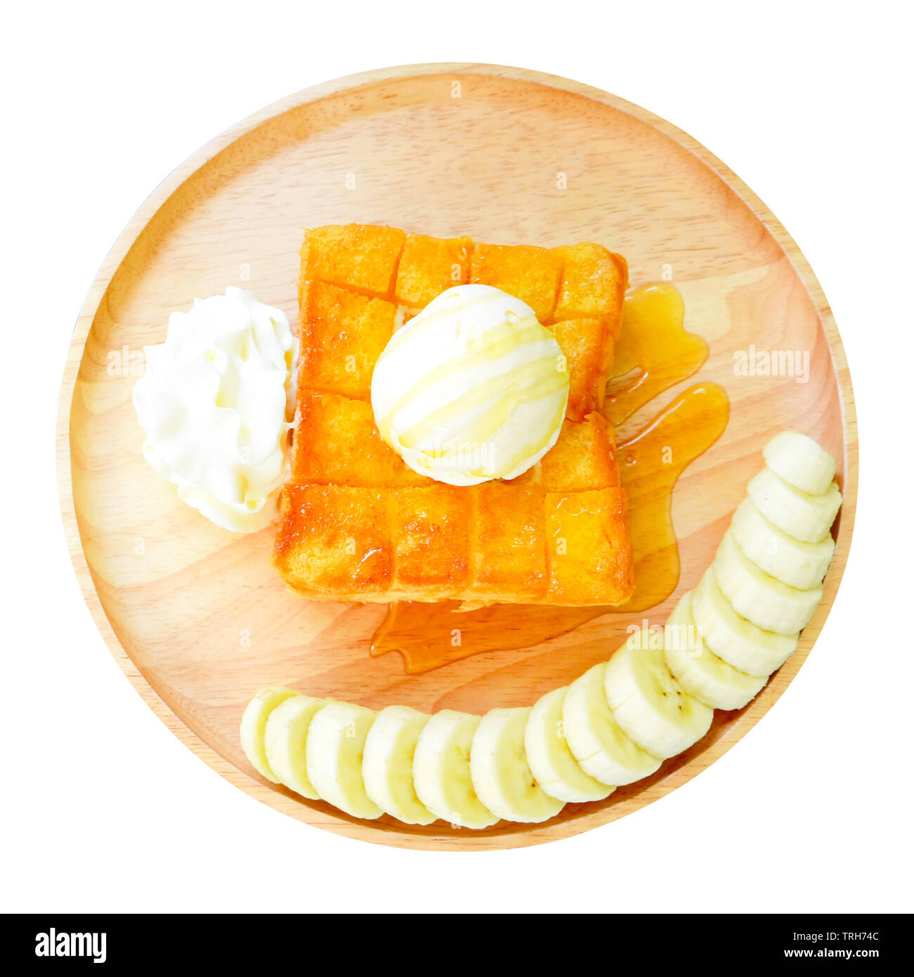 Honey Toast with Banana on Wooden Plate. Top View. Toast Bread Pudding with Vanilla Ice Cream and Whipped Cream Isolated on White Background Stock Photo