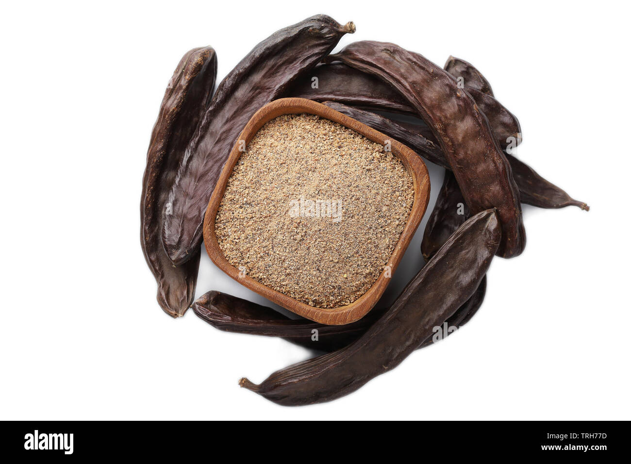 Ground carob (Ceratonia siliqua) powder with carob bean pods isolated