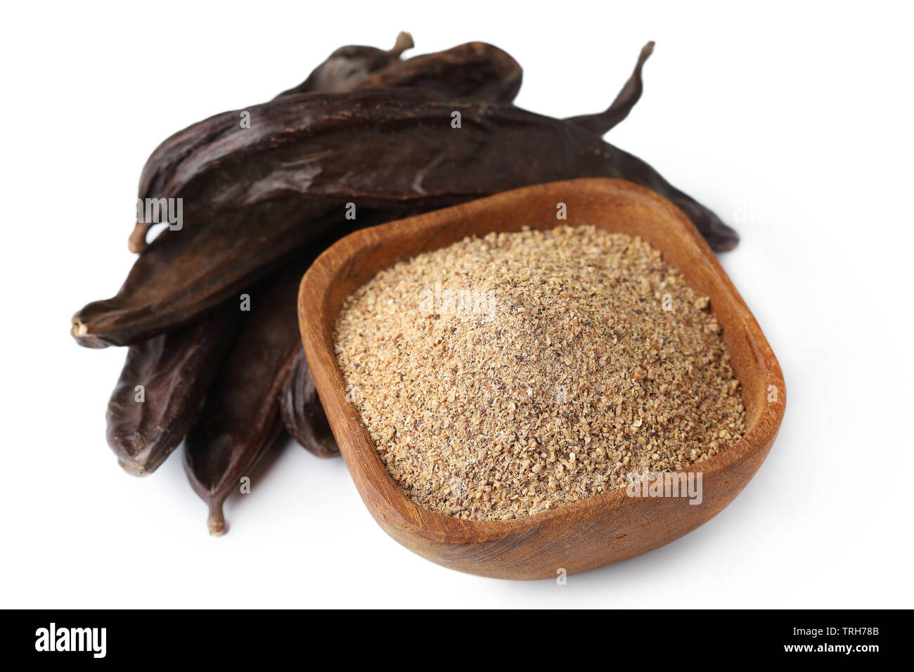 Ground carob (Ceratonia siliqua) powder with carob bean pods isolated