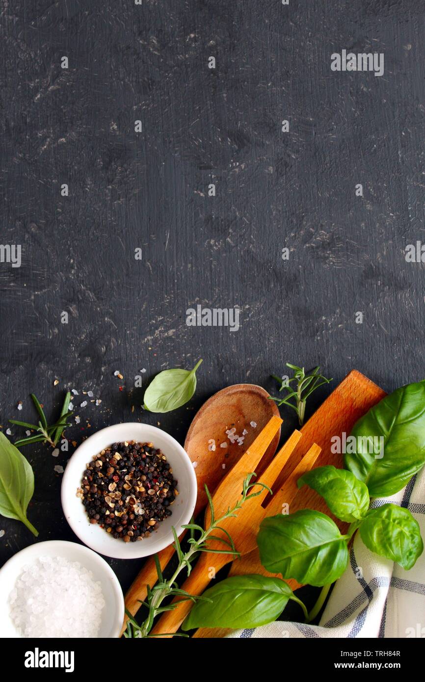 Wooden spoon and knife with ingredients on dark background. Top view ...