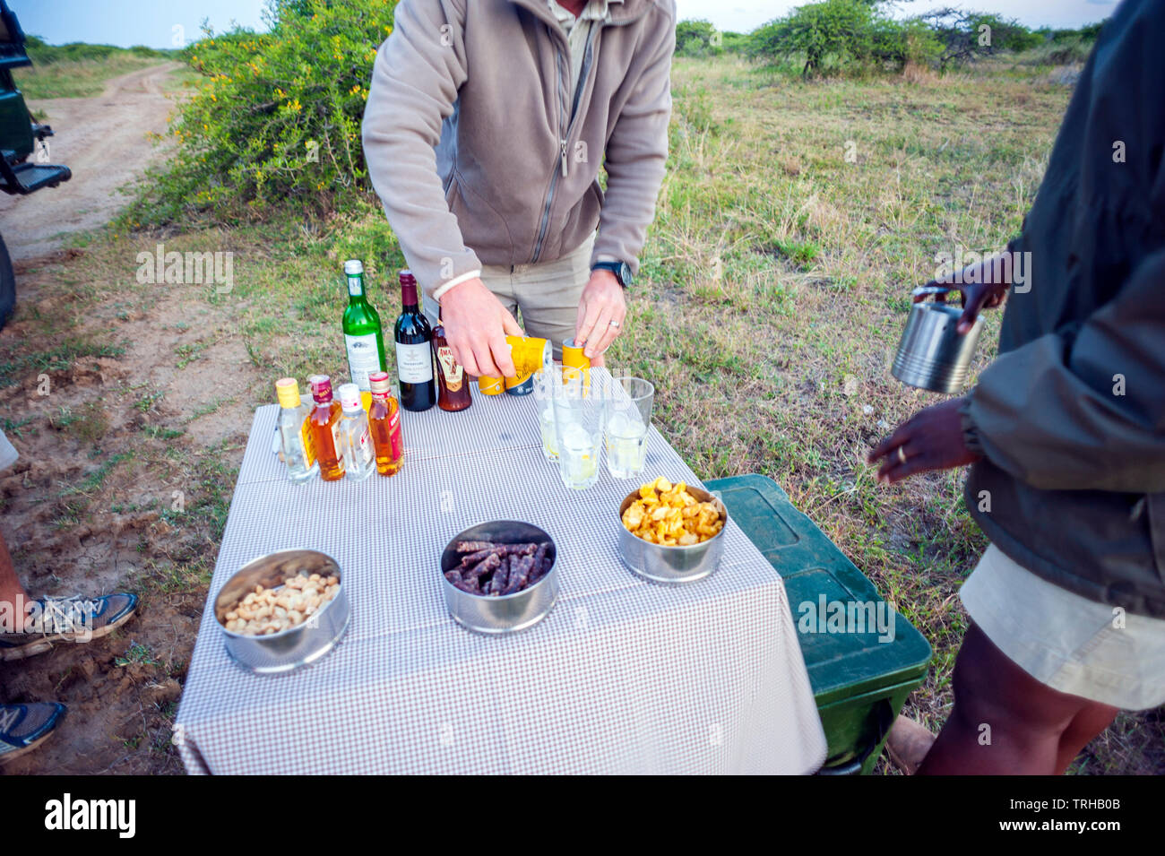 A guide and tracker prepare cocktails at the Phinda Private Game Reserve, an andBeyond owned nature reserve in eastern South Africa. Stock Photo