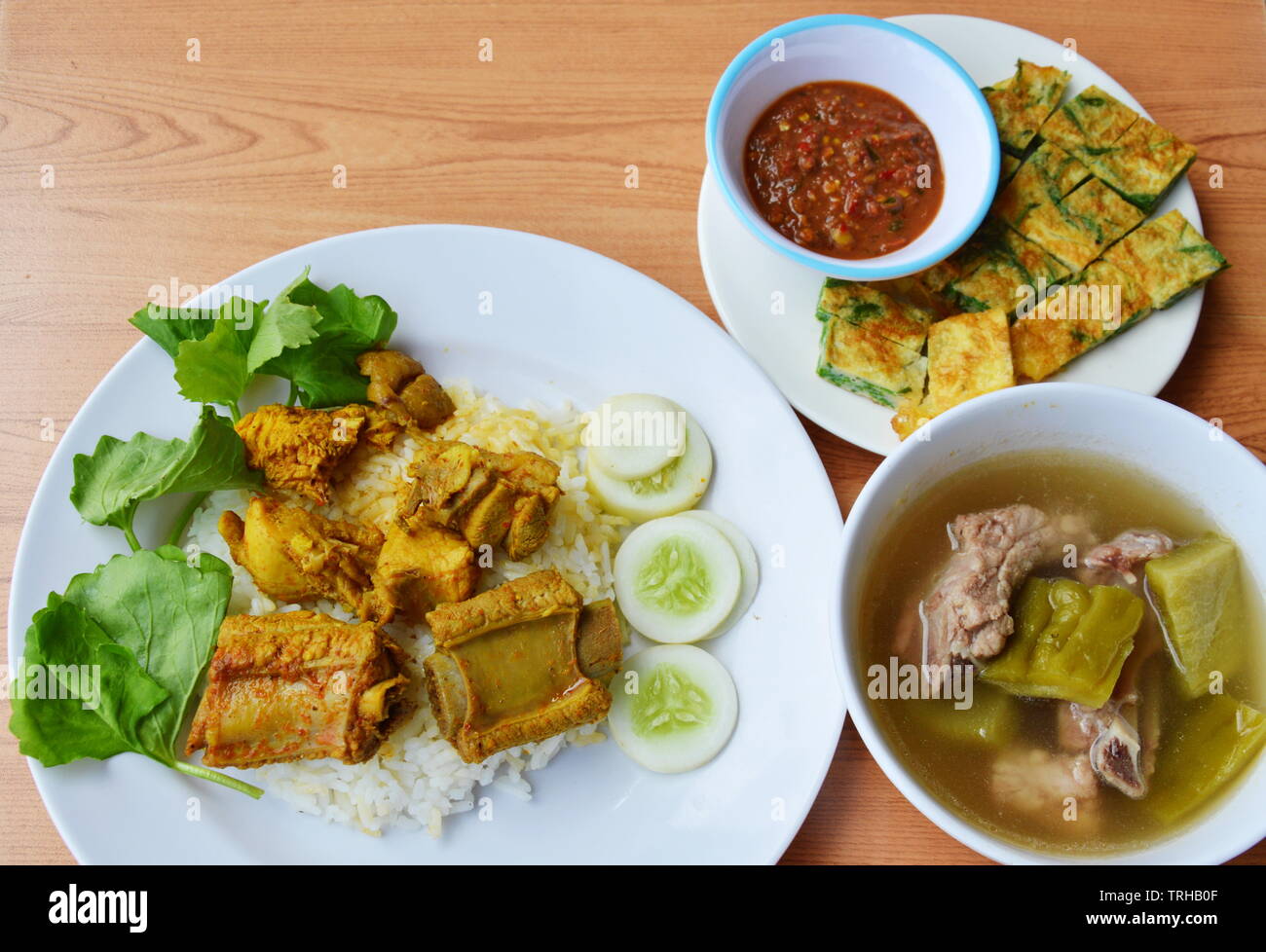 pork rib in yellow curry on rice with fried egg and soup Stock Photo
